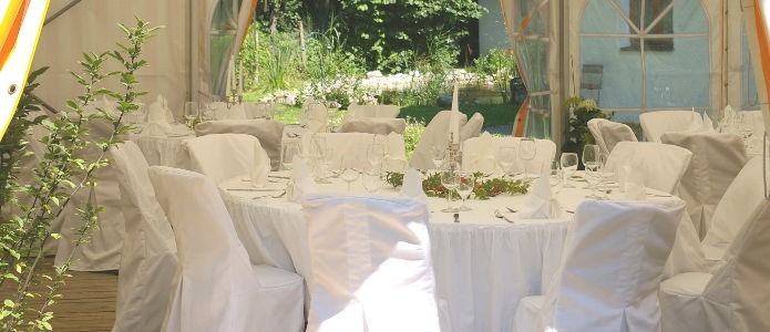 Dekorierter Tisch mit Stühlen und Hussen für eine Hochzeitsfeier